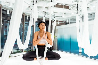 Lotus pozisyonu Anti yerçekimi yogada ışık Studio namaste mudra hareketi ile pratik kız