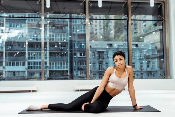 Atractiva Chica Deportiva Mirando Cámara Mientras Está Sentado Estera Gimnasio — Foto de stock gratuita