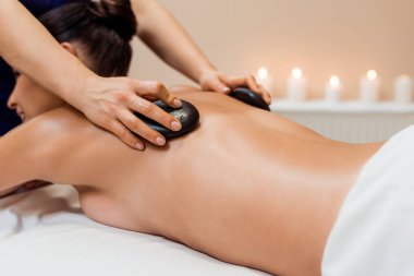 atış genç kadın sıcak taş spa merkezinde masaj sahip kırpılmış
