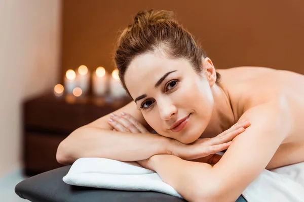 Jovem Atraente Deitado Mesa Massagem Sorrindo Para Câmera — Fotografia de Stock