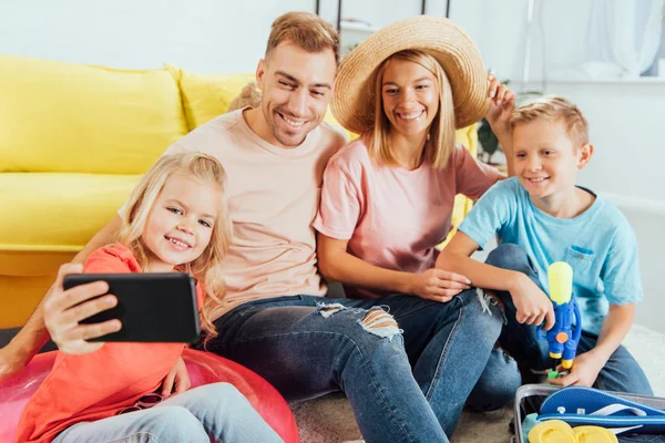 Família Feliz Tomando Selfie Smartphone Enquanto Faz Malas Para Férias — Fotografia de Stock Grátis