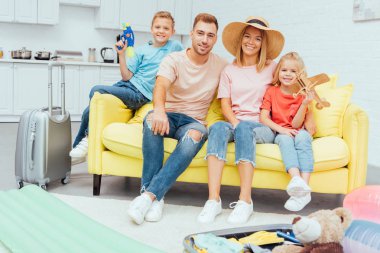 sonra yaz tatili için ambalaj aile kanepede dinlenme gülümseyen, seyahat kavramı