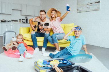 mutlu aile pasaport holding, yaz tatili için Bagaj paketleme ve harika vakit geçiriyor seyahat kavramı