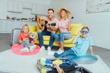 mutlu aile pasaport holding, yaz tatili için Bagaj paketleme ve harika vakit geçiriyor seyahat kavramı