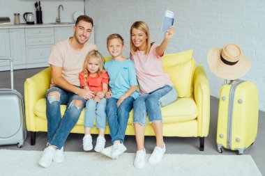 mutlu aile pasaport holding, yaz tatili için Bagaj paketleme ve harika vakit geçiriyor seyahat kavramı