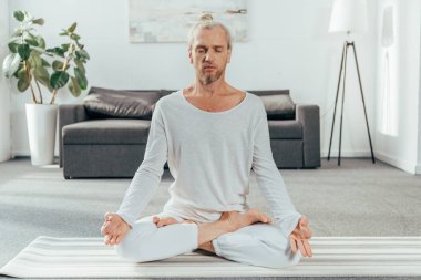 yoga mat evde lotus pozisyonda meditasyon sportif yetişkin adam 