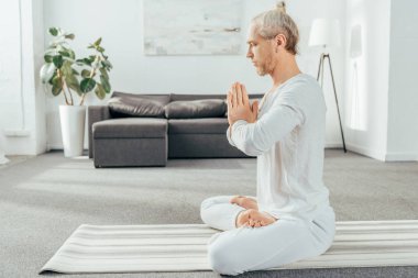 namaste hareketi evde ile lotus pozisyonda meditasyon adam yan görünüm  