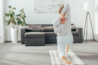 arkadan görünüşü diz yoga pose üzerinde evde hilal hamle pratik adam