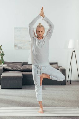 sportif yetişkin adam ağaç poz yoga mat evde pratik