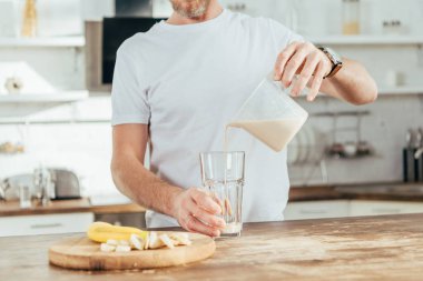 evde cam kırpılmış shot yetişkin adam dökme muz protein sallamak