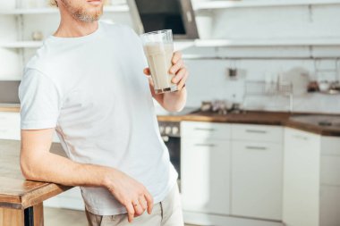 kırpılmış cam protein shake ile evde tutan sportif adam kadeh