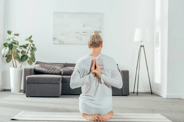 Back View Man Sitting Yoga Pose Hands Back Home — Free Stock Photo