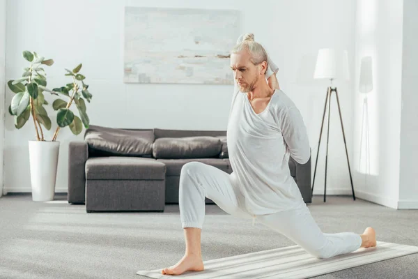 Bărbat Practicând Crescent Lunge Genunchi Yoga Pozează Domiciliu — Fotografie de stoc gratuită