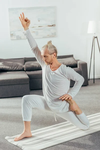 Athletische Flexible Erwachsene Mann Praktiziert Yoga Auf Matte Hause — kostenloses Stockfoto