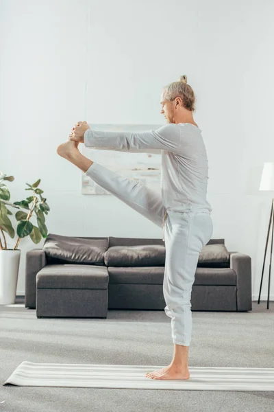 Vista Laterale Dell Uomo Adulto Scalzo Che Pratica Yoga Casa — Foto stock gratuita