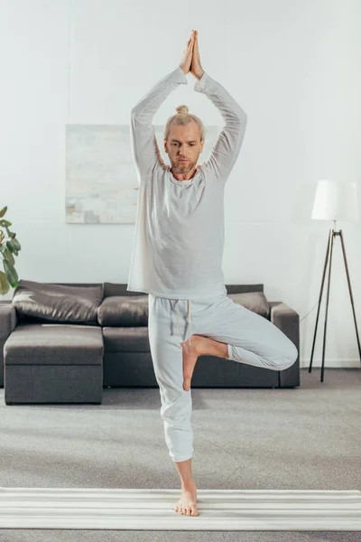 Sportig Vuxen Man Öva Tree Pose Yogamattan Hemma — Stockfoto