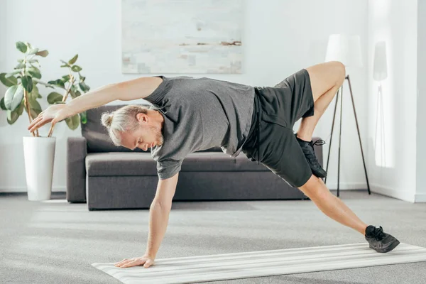 Flexibla Atletisk Man Sportkläder Öva Sida Planka Yogamattan Hemma — Stockfoto
