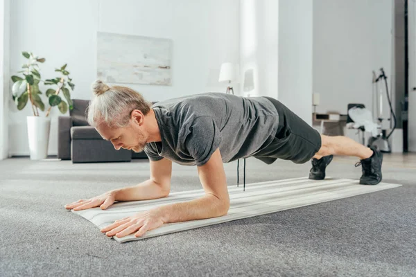 Sportig Vuxen Man Sportkläder Gör Plankan Övning Yogamattan Hemma — Stockfoto