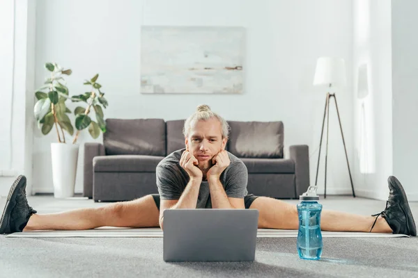 Uomo Adulto Sportivo Che Diviso Stuoia Yoga Guardando Computer Portatile — Foto stock gratuita