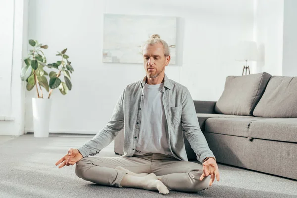 Sporty Adult Man Meditating Lotus Position Home — Free Stock Photo