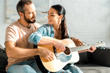 Akustik gitar çalmayı eş gülümseyen öğretim koca