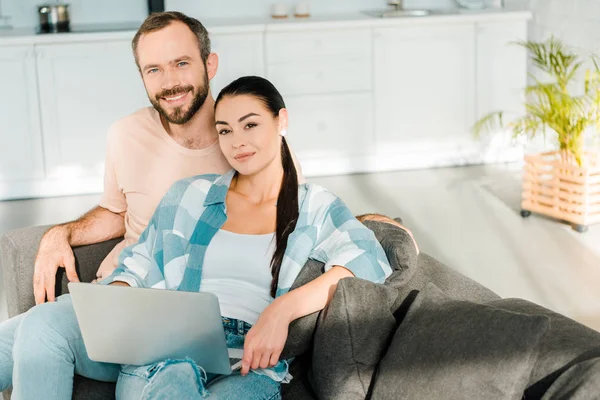 Husband Attractive Wife Sitting Couch Looking Camera Using Laptop Home — Free Stock Photo