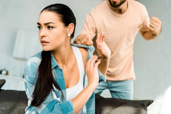 Marido Tentando Bater Esposa Sentado Sofá Casa — Fotografia de Stock