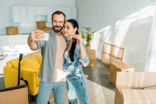 Happy Moving Couple Taking Selfie Smartphone While Wife Holding Keys — Stock Photo, Image