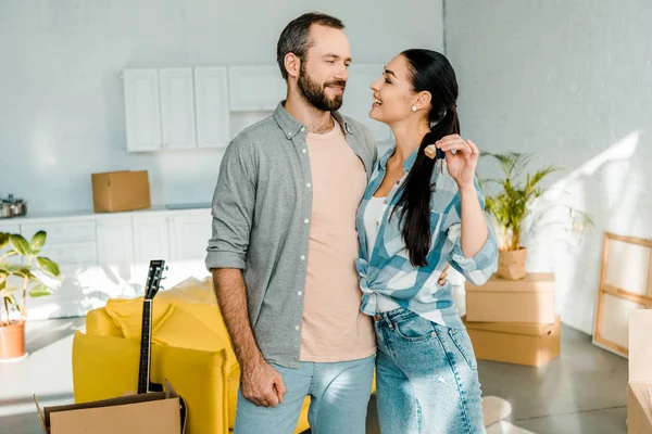 Sonriente Pareja Abrazando Sosteniendo Las Llaves Nueva Casa Concepto Movimiento —  Fotos de Stock