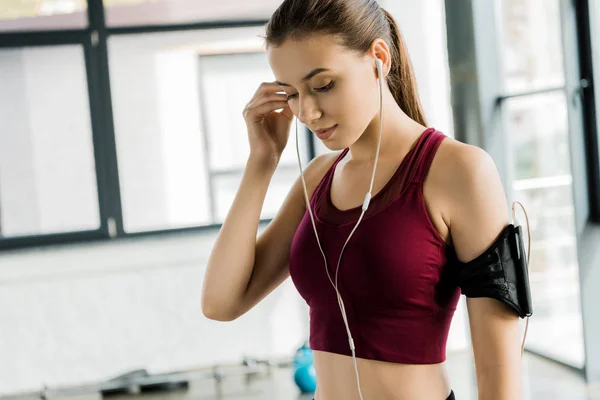 Hermosa Deportista Delgada Brazalete Teléfono Inteligente Poner Los Auriculares Gimnasio —  Fotos de Stock