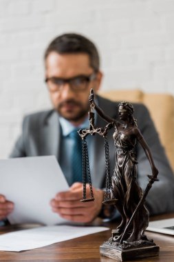 close-up view of lady justice statue and male lawyer working behind  clipart