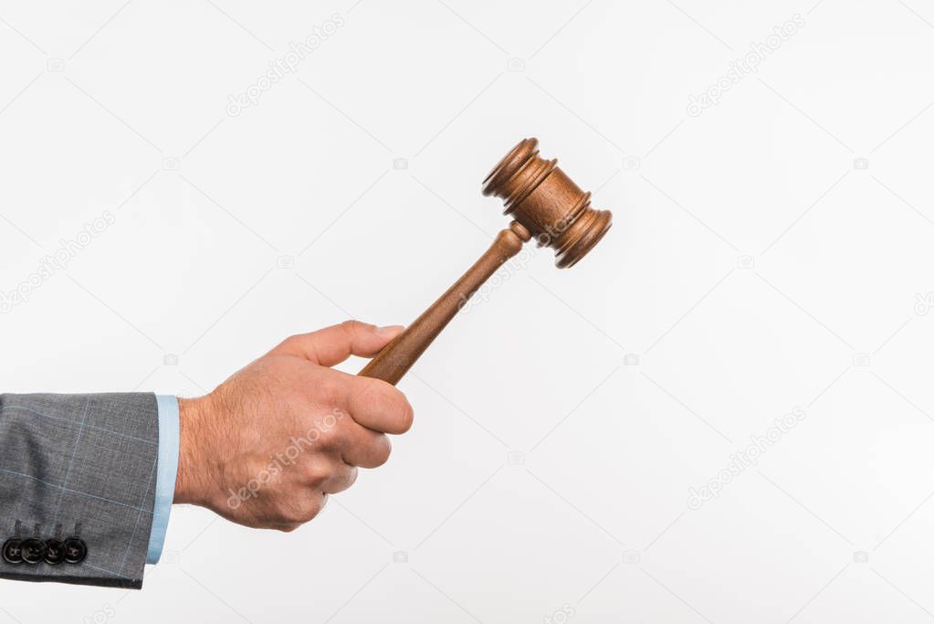 cropped shot of judge holding wooden hammer in hand isolated on white 
