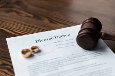 divorce decree, wedding rings and judge hammer on wooden table clipart