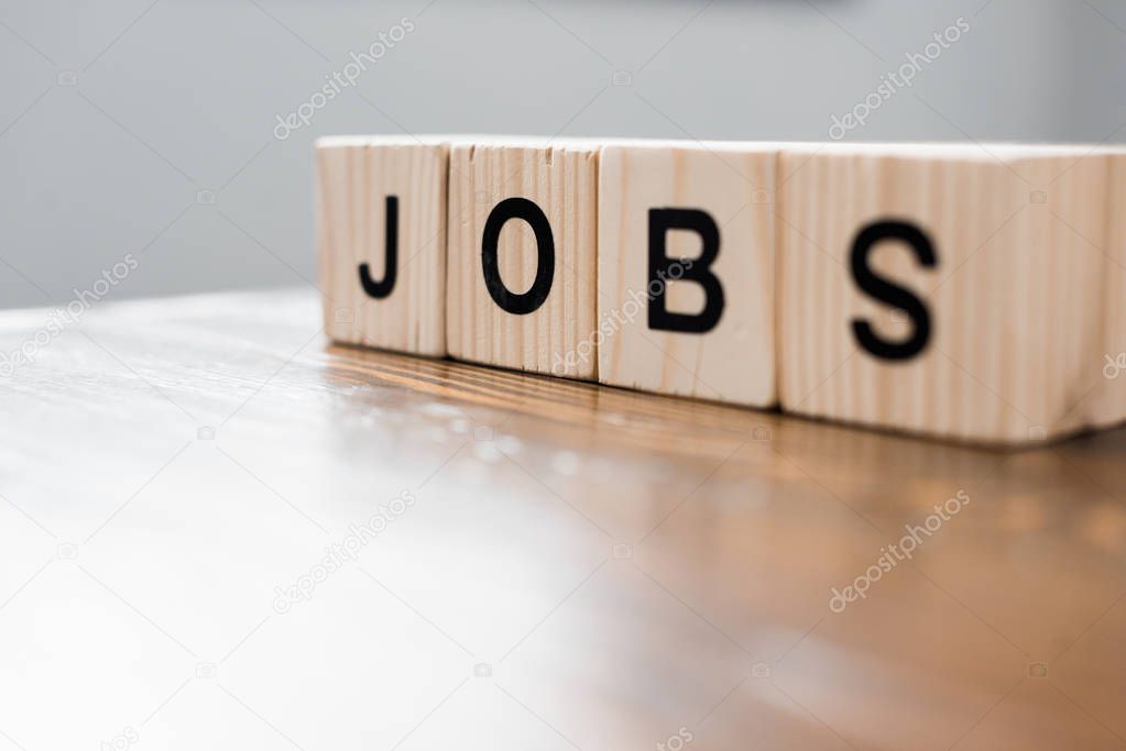 close-up shot of wooden blocks with JOBS sign on table