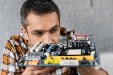 close-up portrait of handsome computer engineer with motherboard