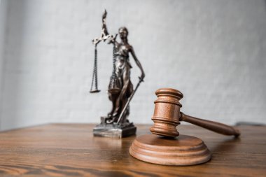 close-up shot of judge gavel and themis statue on wooden table clipart