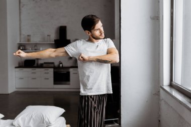 egzersiz ve sabah penceresine bakarak pijama genç adam