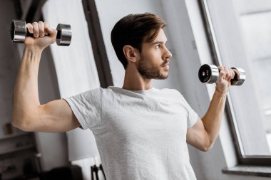 Dambıl ile egzersiz ve evde penceresine bakarak yakışıklı delikanlı