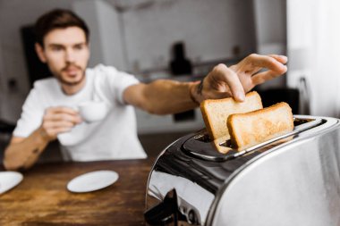 kahve içme ve tost ekmek kızartma makinesi alarak genç adam yakın çekim çekim