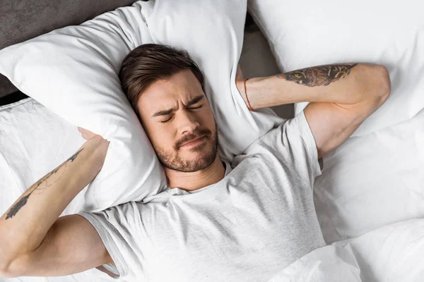 Vista Superior Del Joven Cerrando Las Orejas Con Almohada Cama — Foto de Stock