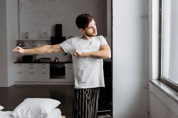 Young Man Pajamas Exercising Looking Window Morning — Free Stock Photo