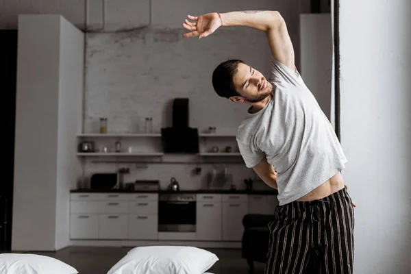 Handsome Young Man Pajamas Stretching Looking Away Morning Home — Free Stock Photo