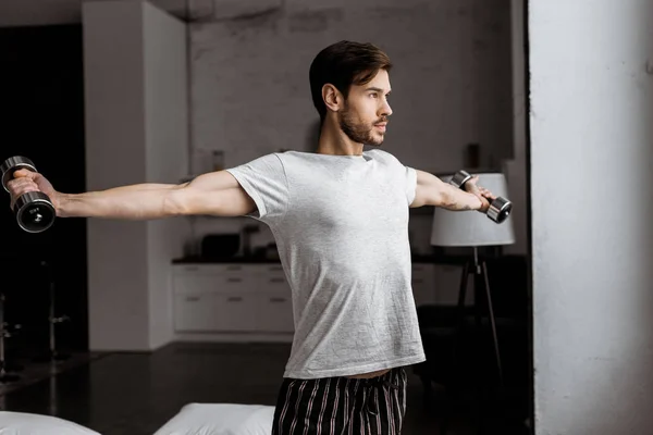 Handsome Young Man Pajamas Training Dumbbells Looking Away Home — Stock Photo, Image