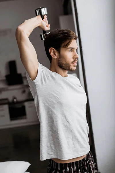 Handsome Young Man Pajamas Exercising Dumbbell Looking Away Morning — Stock Photo, Image