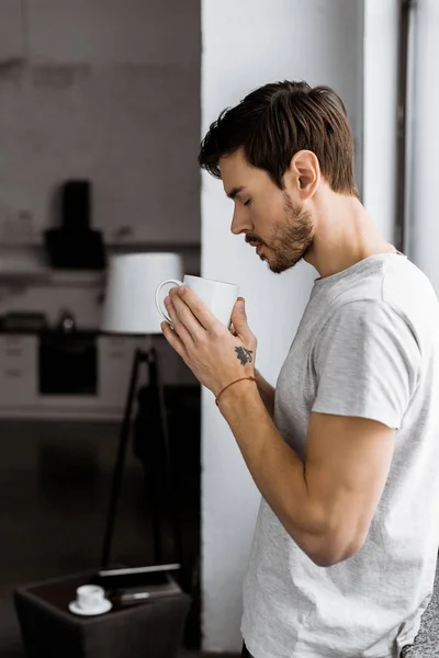 Seitenansicht Eines Hübschen Jungen Mannes Mit Kaffeebecher Der Sich Hause — kostenloses Stockfoto