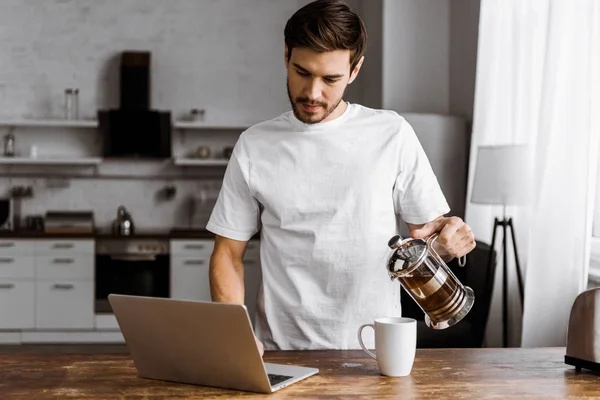 Atractivo Joven Freelancer Con Taza Croissant Portátil Trabajando Cocina Casa — Foto de Stock