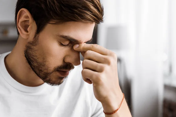 Close Portret Van Depressieve Jongeman Aanraken Van Neus Brug Thuis — Stockfoto