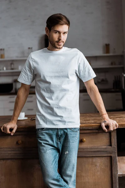 Joven Guapo Recostado Mesa Cocina Mirando Cámara Casa — Foto de Stock