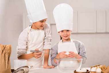 küçük çocuklarda önlük ve chef şapka mutfak masasında hazırlanıyor 