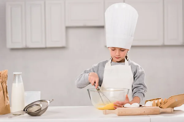 Niño Concentrado Sombrero Del Chef Batiendo Huevos Tazón Mesa Cocina — Foto de Stock